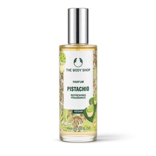 A 40ml bottle of The Body Shop Pistachio Parfums Refreshing Fragrance, featuring a clear glass bottle with a silver cap, filled with a light yellow liquid and decorated with green pistachio illustrations on a white label.